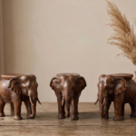Handcrafted wooden elephant stool set with detailed carving and natural wood finish placed on a table